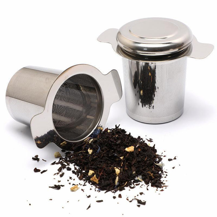 Filtro a cilindro in acciaio inox con coperchio, con tè in foglie sparse accanto