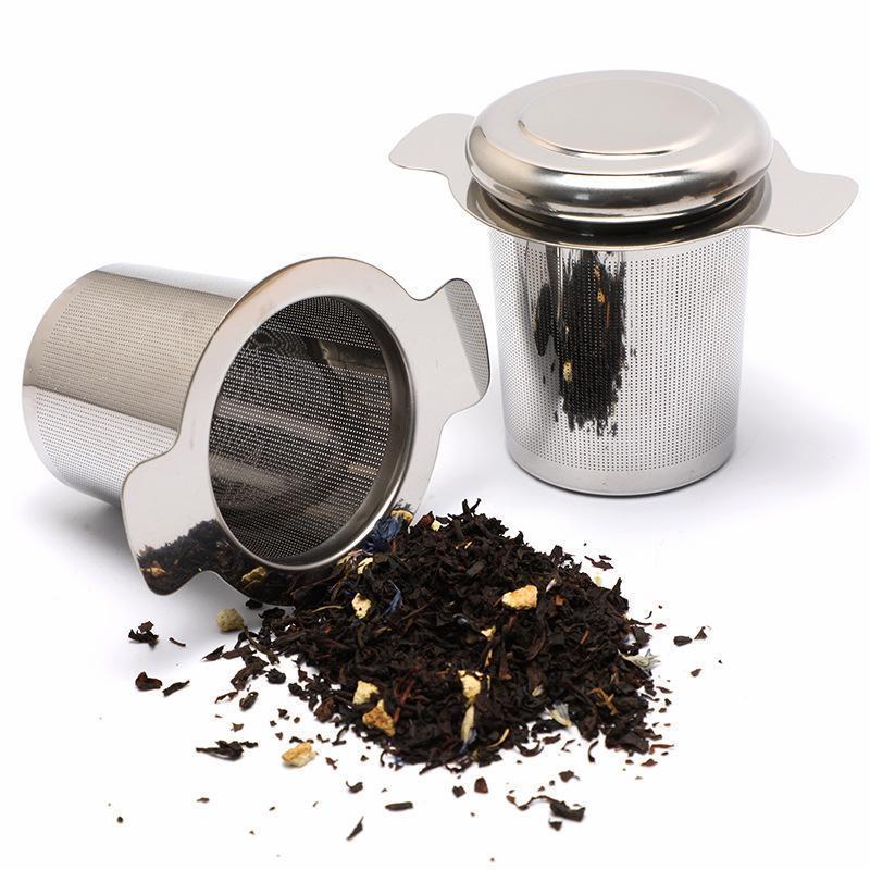 Filtro a cilindro in acciaio inox con coperchio, con tè in foglie sparse accanto