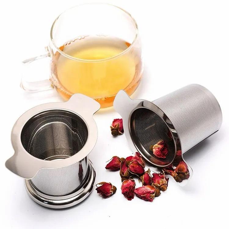 Filtro a cilindro in acciaio inox in uso con una tazza di tè e boccioli di rosa